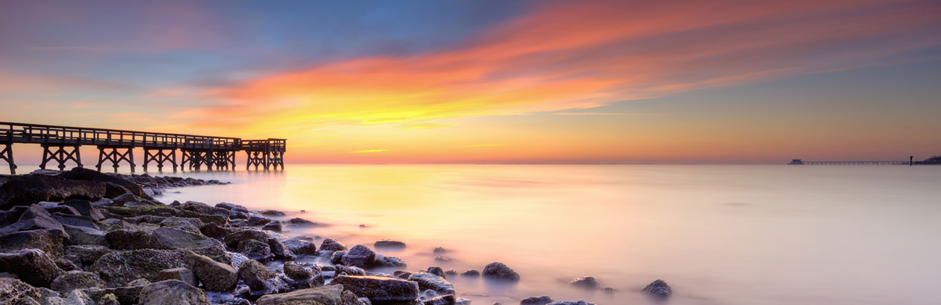 Pier over foggy water at sunrise