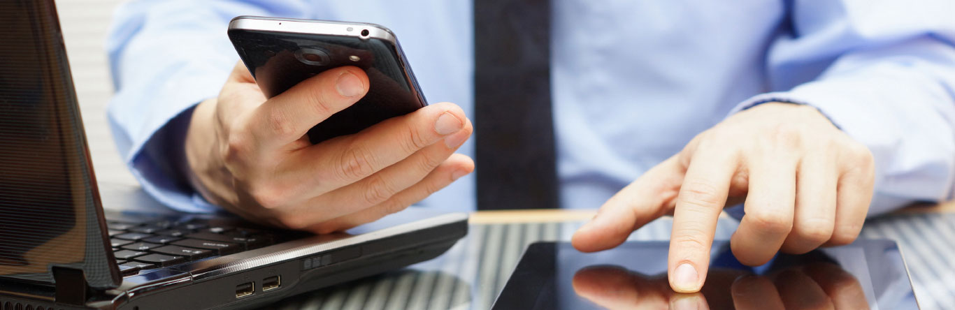 man using mobile phone, laptop computer and tablet