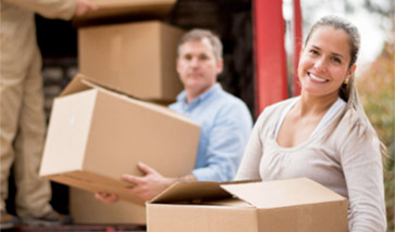 smiling couple loading boxes on truck